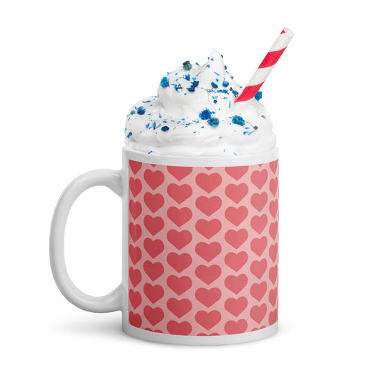 Mug with heart pattern, whipped cream, and a straw on a white background
